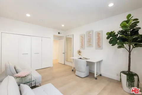 a living room with furniture a potted plant and a table