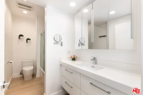 a bathroom with a double vanity sink mirror and toilet