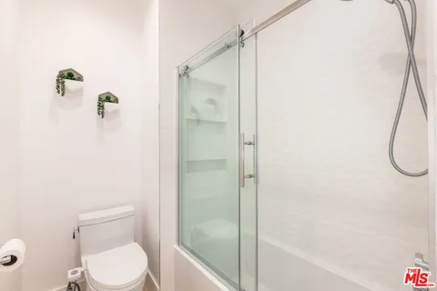 a bathroom with a toilet and a shower