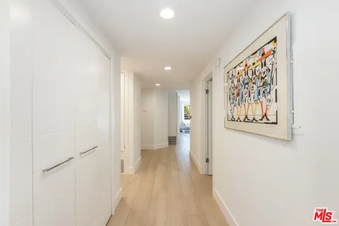a view of a hallway with wooden floor and closet