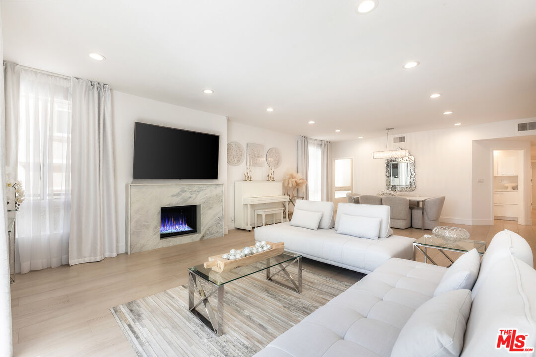 1164 Wellesley Avenue, Unit 101 Los Angeles, CA 90049 - Photo 7 of 25 a living room with furniture a fireplace and a flat screen tv