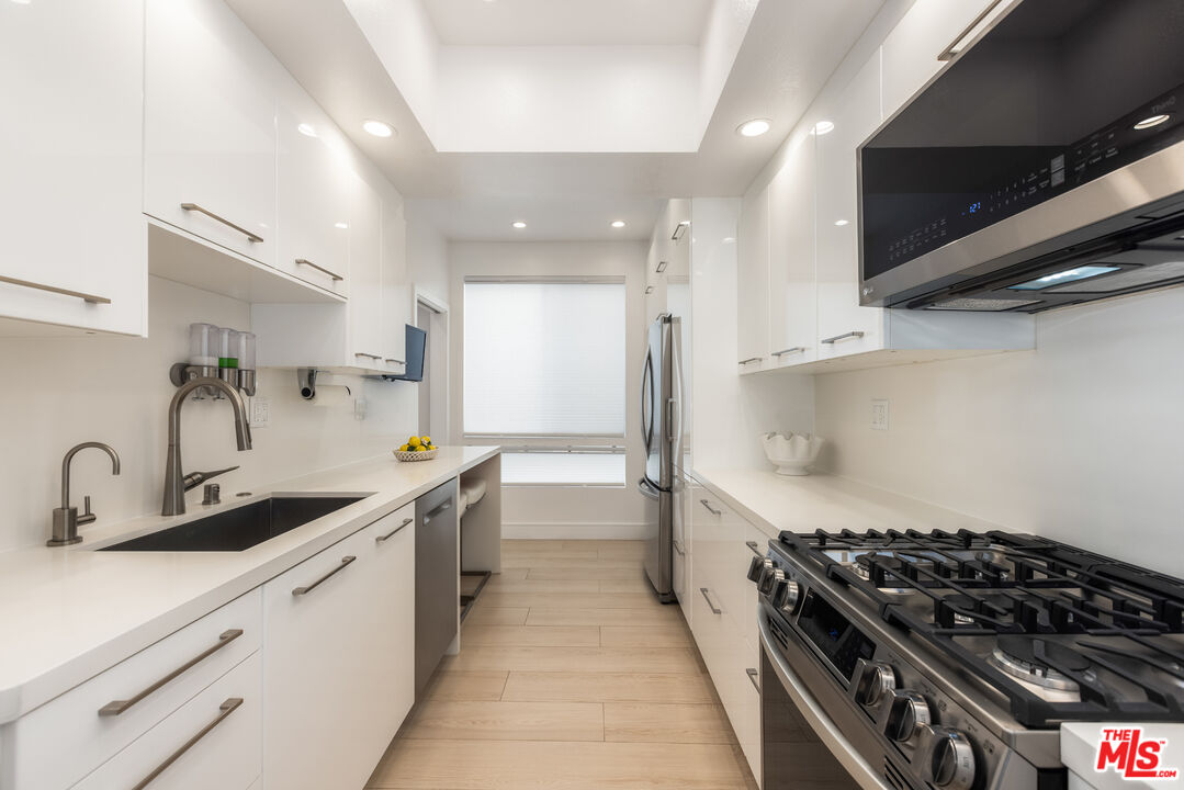 1164 Wellesley Avenue, Unit 101 Los Angeles, CA 90049 - Photo 9 of 25 a kitchen with stainless steel appliances a sink and a stove