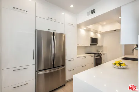 a kitchen with stainless steel appliances a refrigerator and a stove top oven