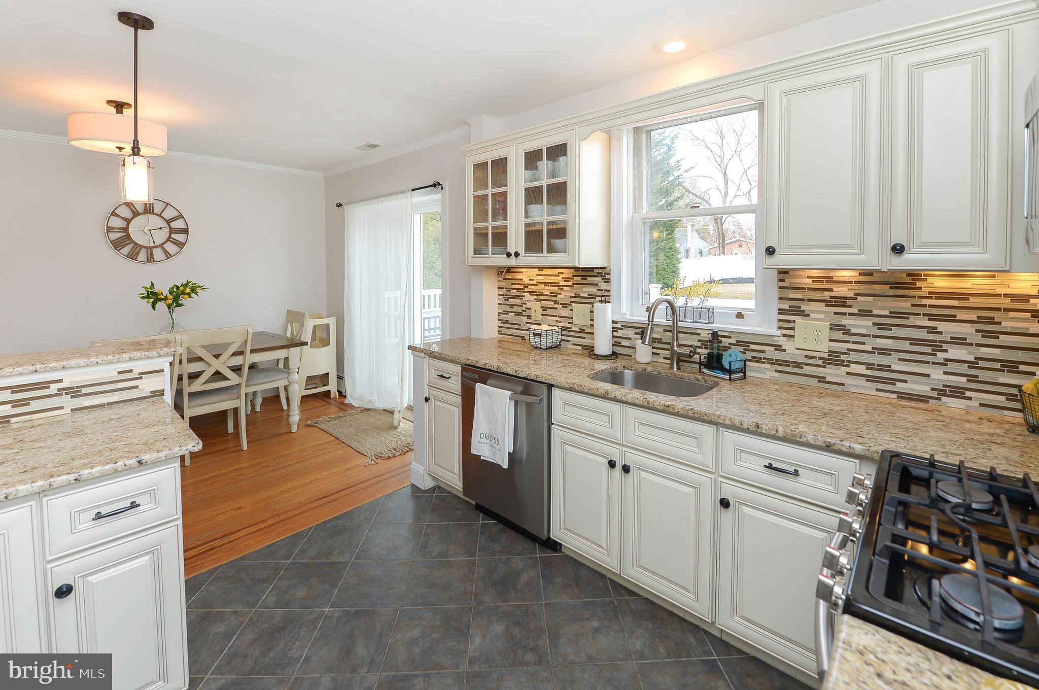 1929 Wayne Avenue Haddon Heights, NJ 08035 - Photo 5 of 36 a kitchen with stainless steel appliances granite countertop a stove a sink and white cabinets with wooden floor