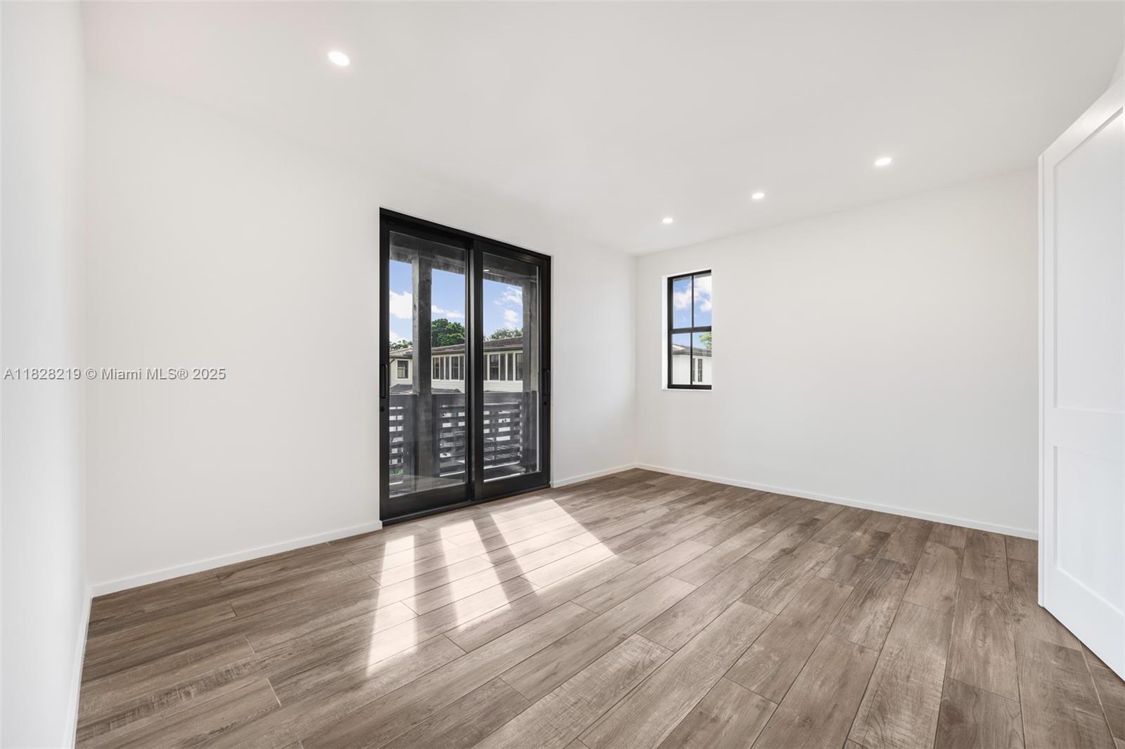 7510 Southwest 100th Street, Unit 12 Pinecrest, FL 33156 - Photo 23 of 36 an empty room with wooden floor and windows