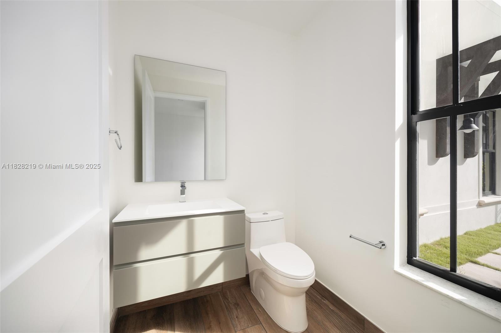 7510 Southwest 100th Street, Unit 12 Pinecrest, FL 33156 - Photo 34 of 36 a bathroom with a sink a toilet and a mirror