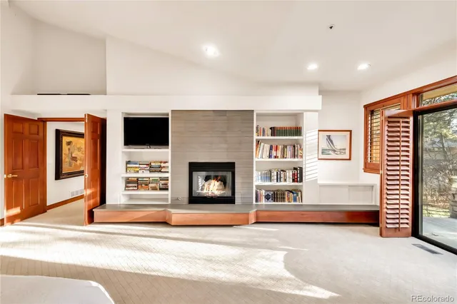 a large living room with stainless steel appliances furniture a rug and a large window