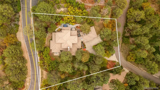 an aerial view of residential houses with outdoor space and trees