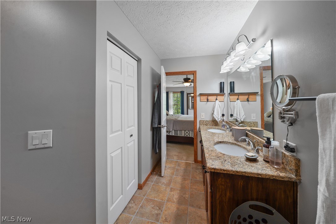 4849 Edson Road Kent, OH 44240 - Photo 22 of 50 Bathroom with dual vanity, tile flooring, ceiling fan, and a textured ceiling