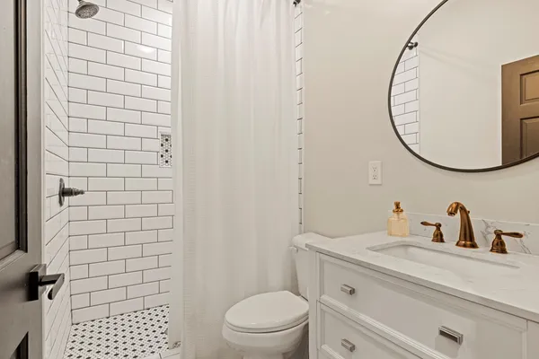 a bathroom with a sink a toilet and a mirror
