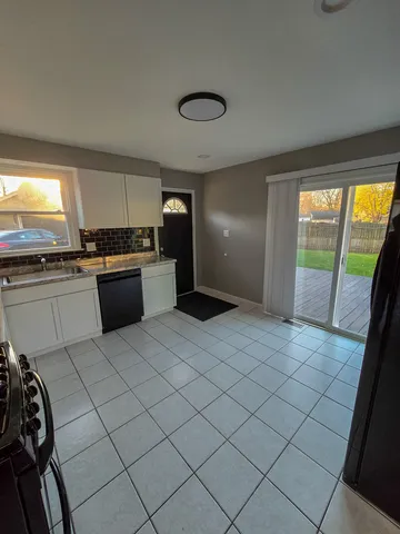 a large white kitchen with a large window