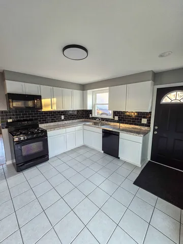 a kitchen with stainless steel appliances granite countertop a stove sink and cabinets