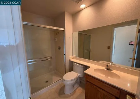 a bathroom with a granite countertop sink toilet a mirror and shower