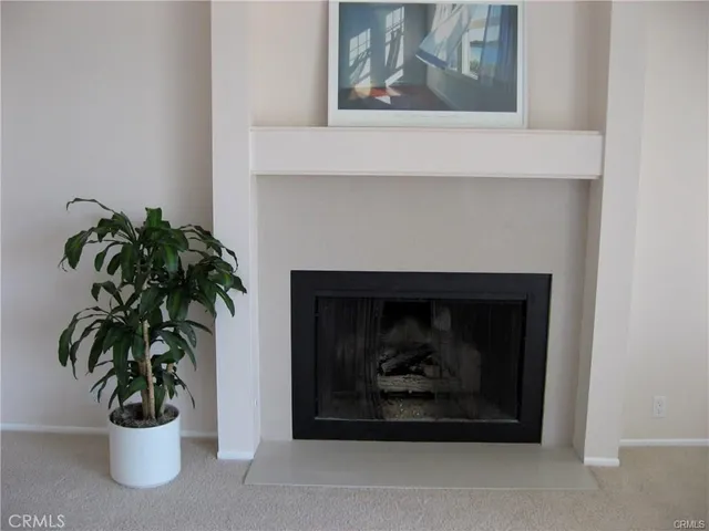 an empty room with windows and fireplace