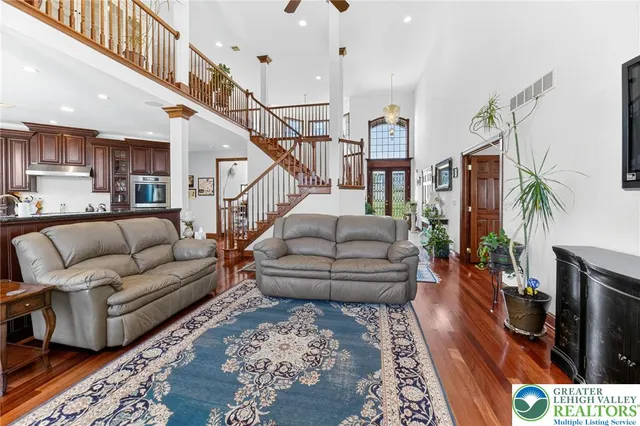 a kitchen with stainless steel appliances granite countertop a refrigerator a stove a sink a dining table and chairs with wooden floor