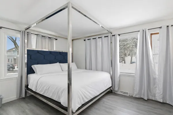 a large bed sitting in a bedroom next to a window