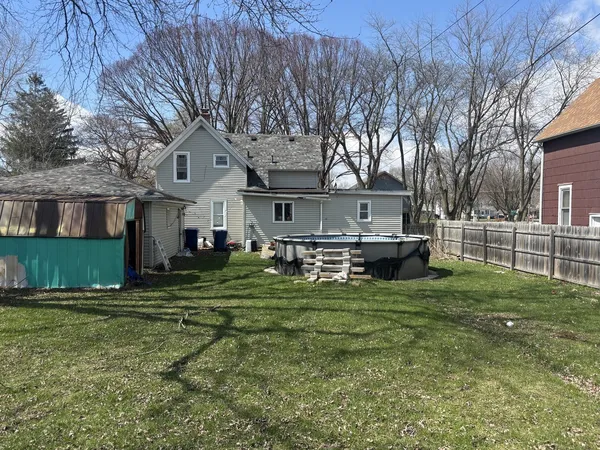 a view of a house with backyard and trees