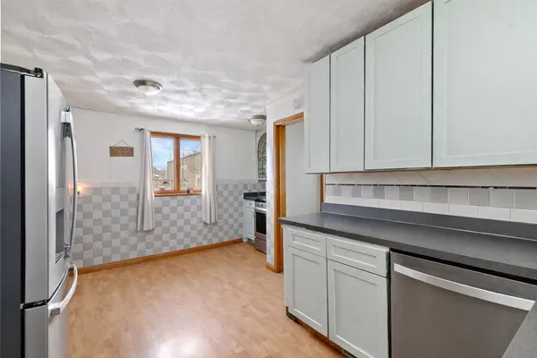 a kitchen with white cabinets and sink