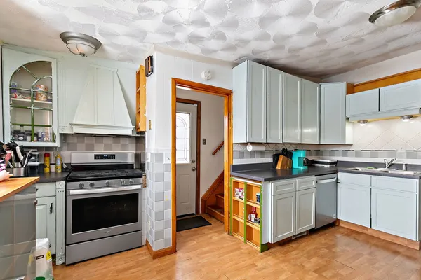 a kitchen with stainless steel appliances granite countertop a stove a sink and a refrigerator