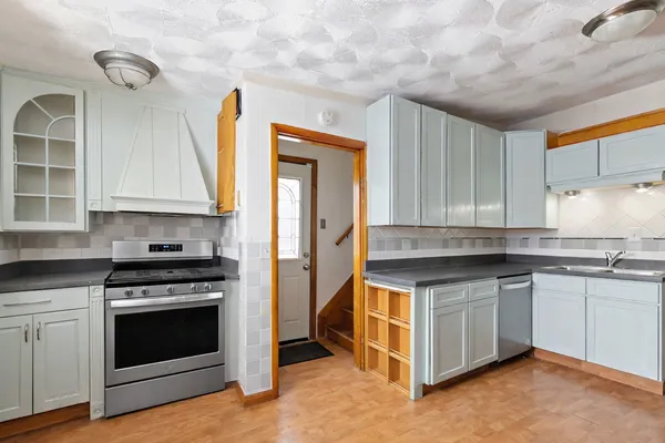a kitchen with granite countertop a stove and a sink