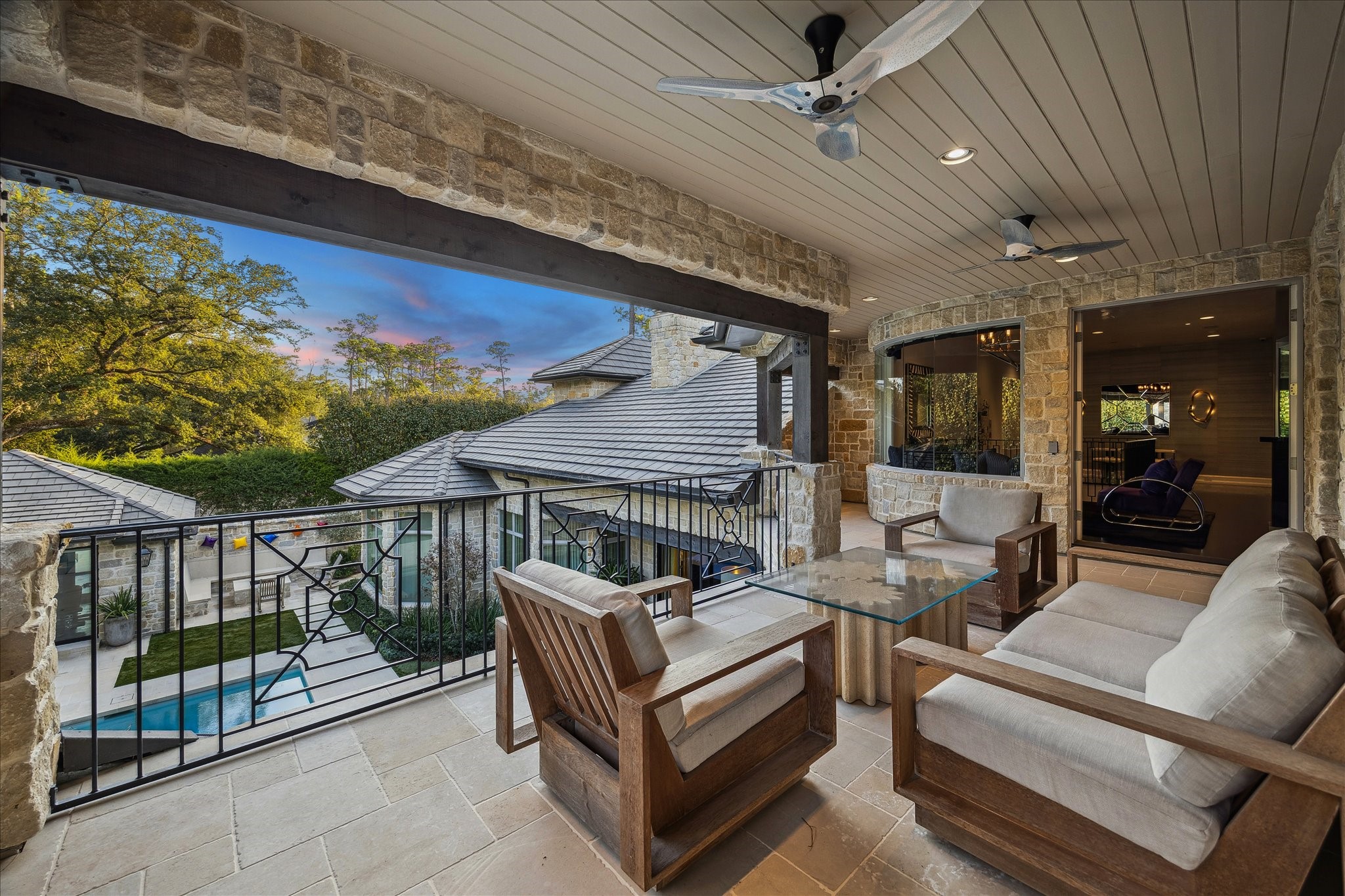 220 Merrie Way Lane Houston, TX 77024 - Photo 37 of 50 The upstairs covered patio offers elevated views of the pool and spa, with dual ceiling fans ensuring comfort in this serene retreat.