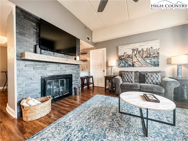 a living room with furniture a flat screen tv and a fireplace