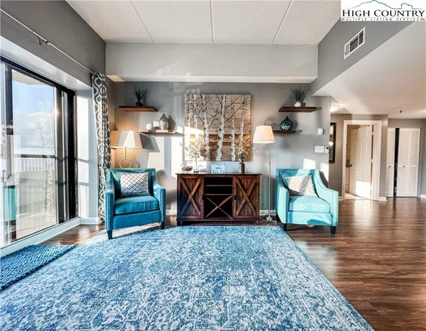 a living room with furniture a air conditioner vent and a window