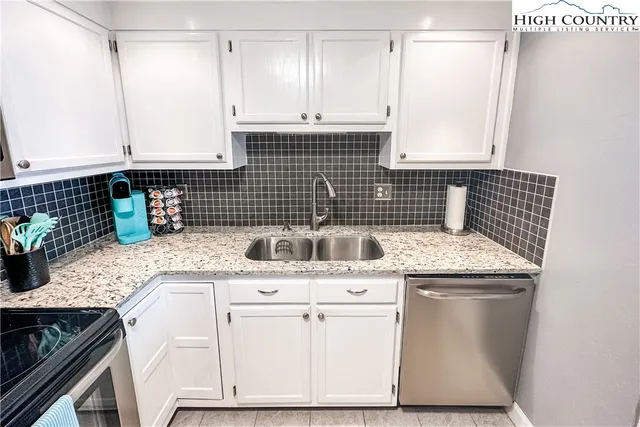 a kitchen with granite countertop a sink stove and cabinets
