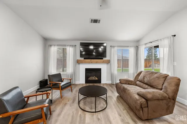 a living room with furniture a flat screen tv and a fireplace