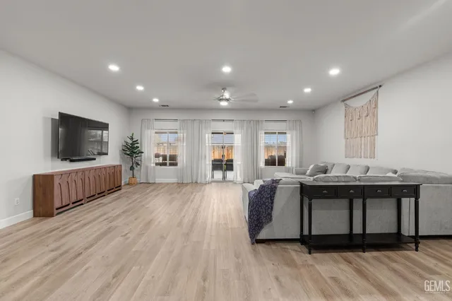 a living room with stainless steel appliances furniture and a flat screen tv