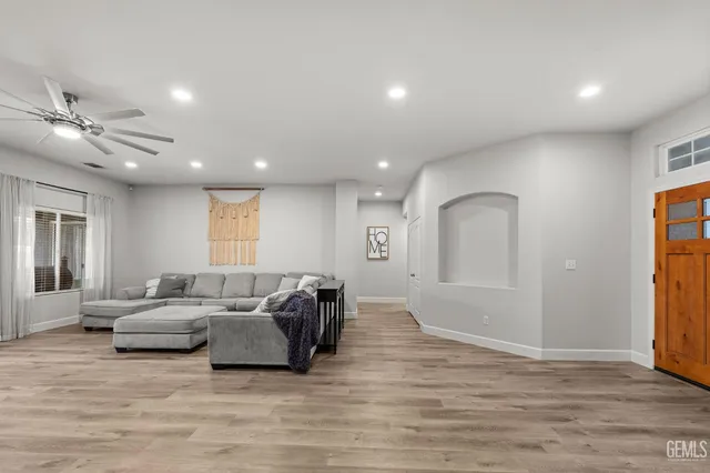 a living room with furniture and a ceiling fan