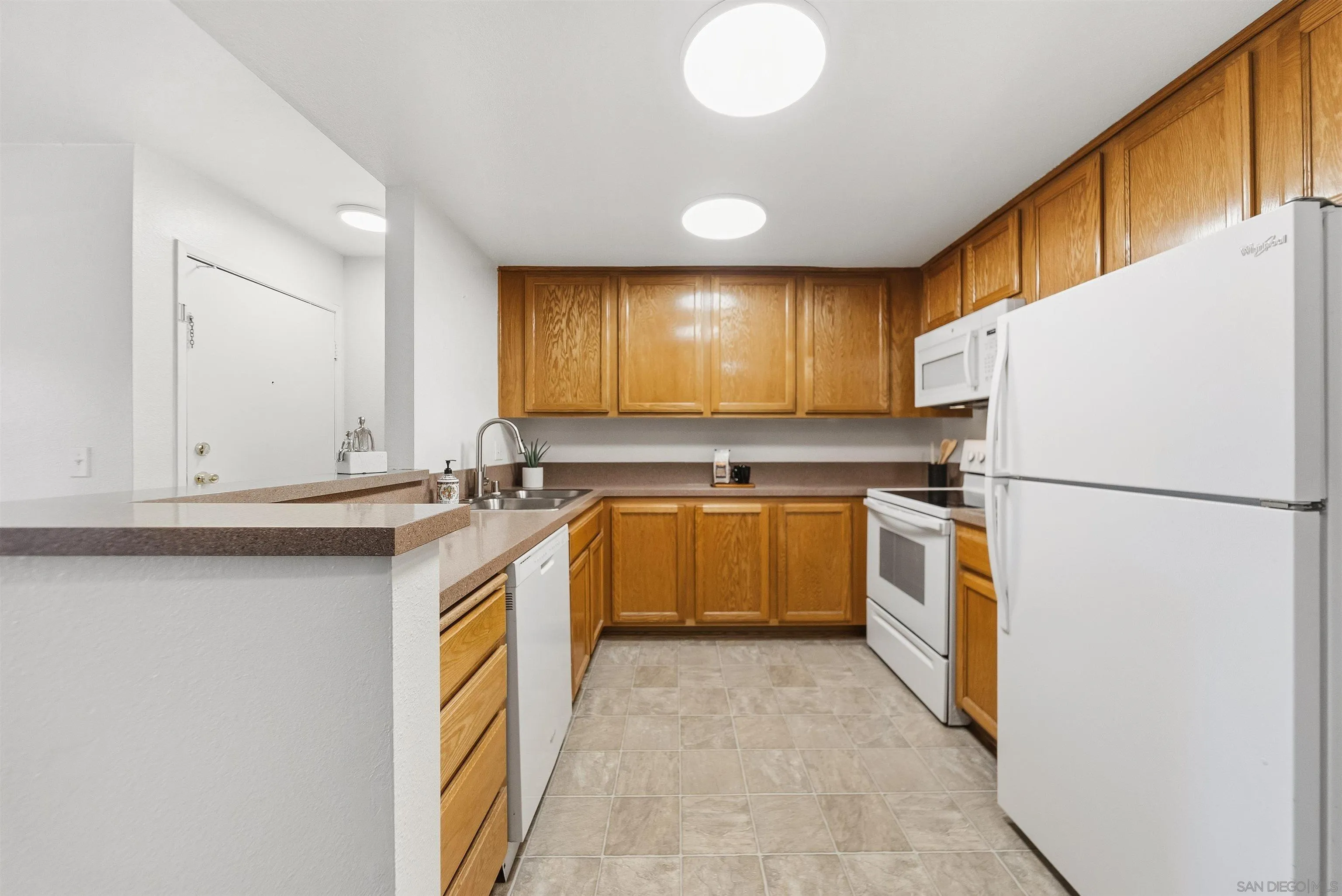 5922 Rancho Mission Road, Unit 74 San Diego, CA 92108 - Photo 13 of 43 a kitchen with a sink a refrigerator and window