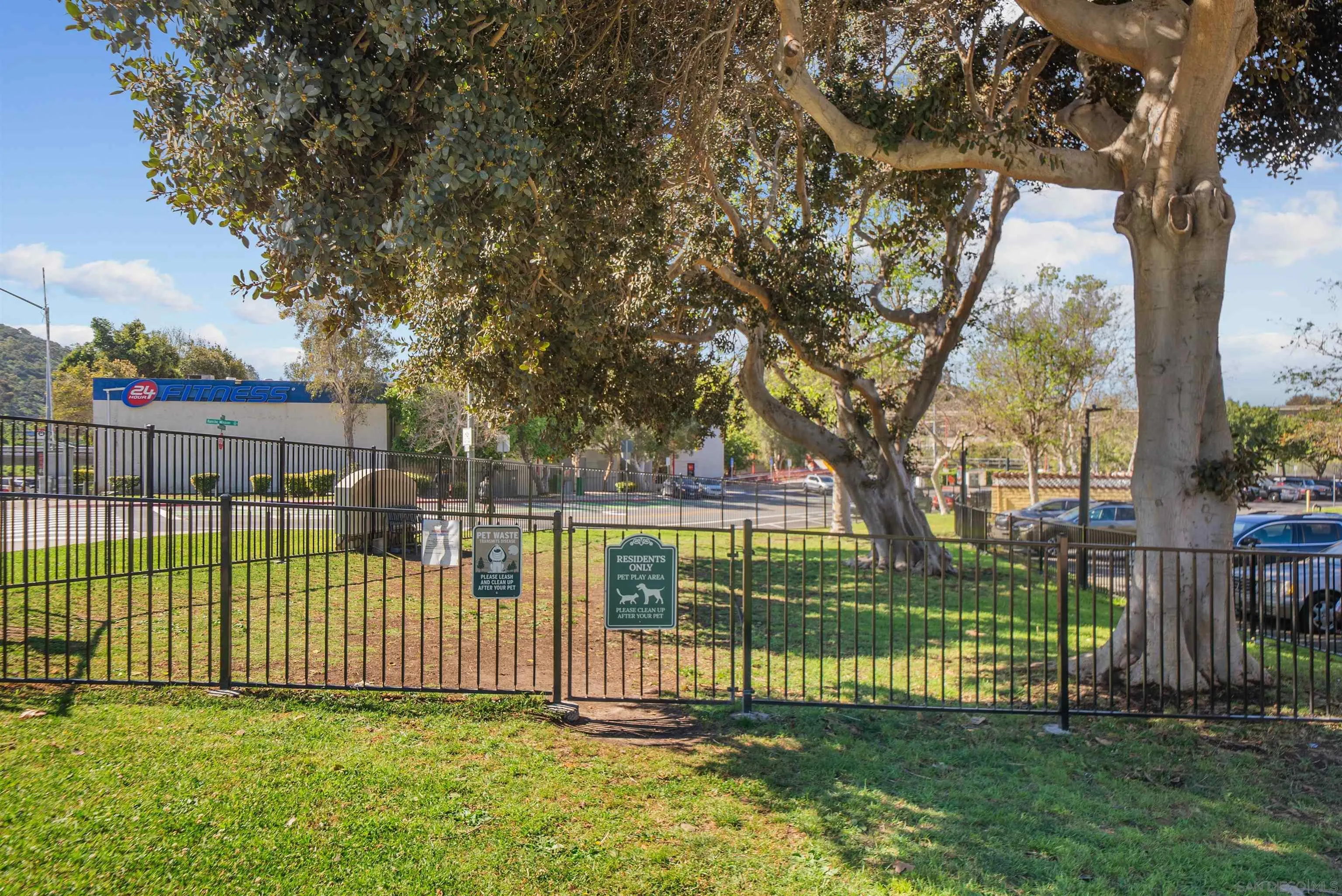 5922 Rancho Mission Road, Unit 74 San Diego, CA 92108 - Photo 32 of 43 a view of a yard with a fence and a large tree