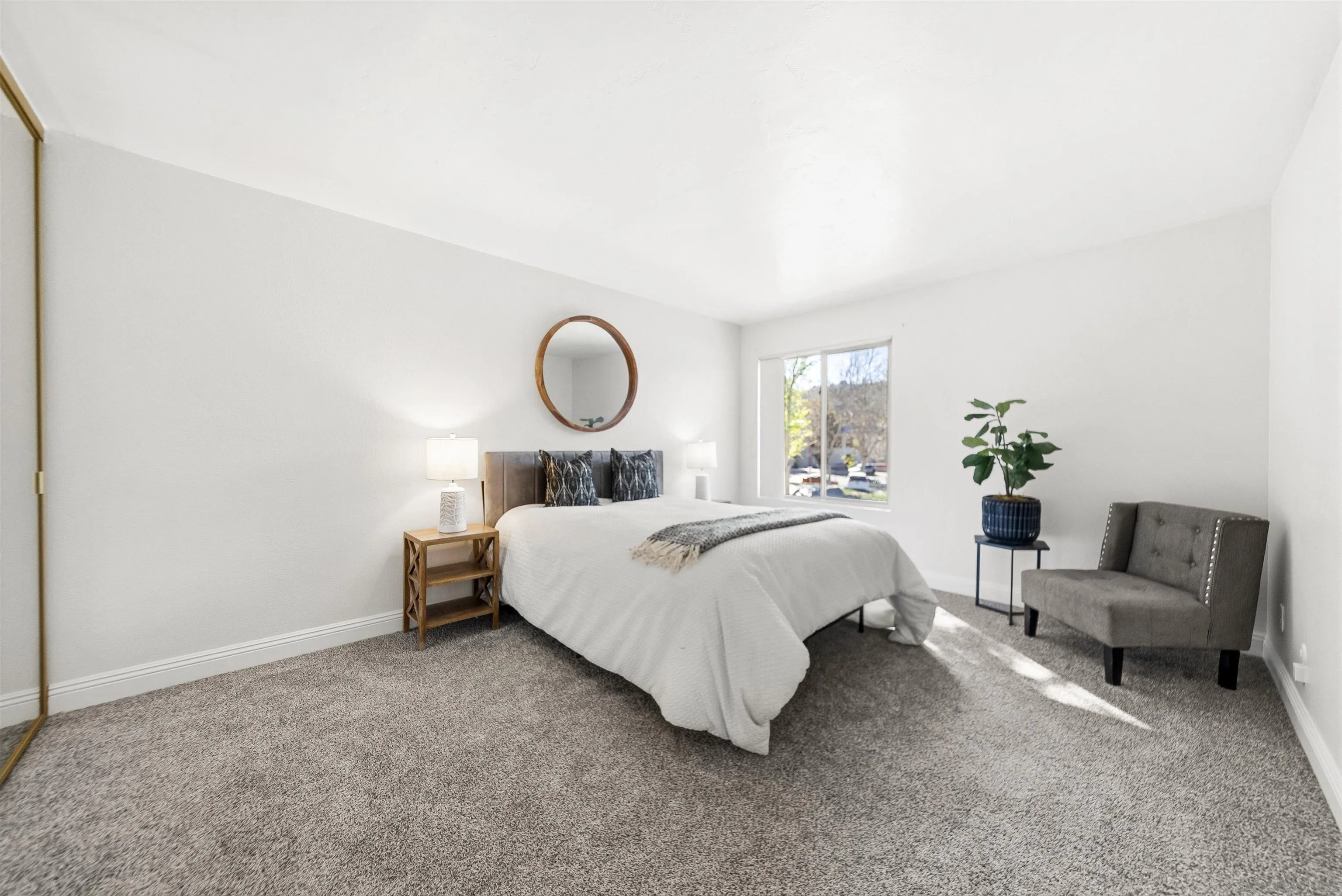 5922 Rancho Mission Road, Unit 74 San Diego, CA 92108 - Photo 5 of 43 a bedroom with a bed a couch and dresser