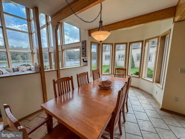 a view of a dining room with furniture large windows and wooden floor