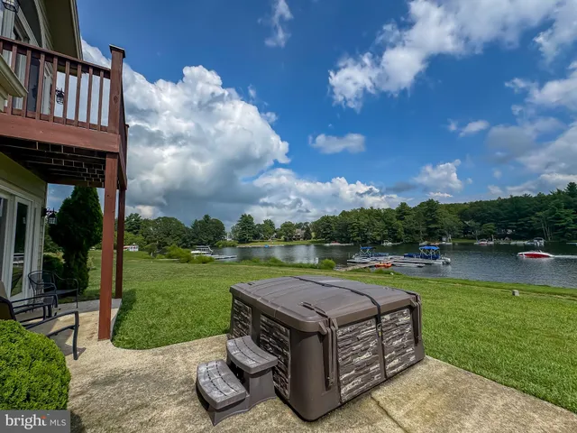 a backyard of a house with lots of green space and lake view