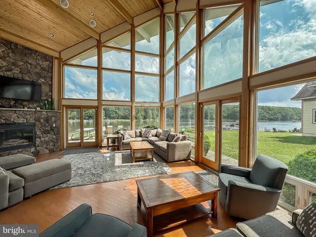 a living room with fireplace furniture and a large window