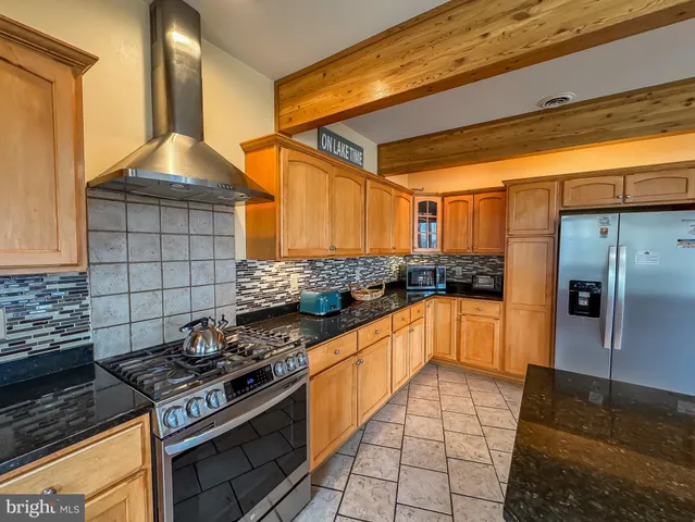 a kitchen with stainless steel appliances granite countertop a stove a sink dishwasher and a refrigerator