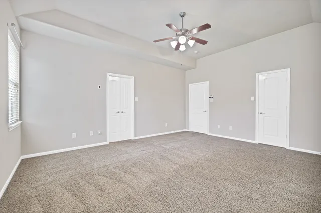 a view of a livingroom with wooden floor and a ceiling fan