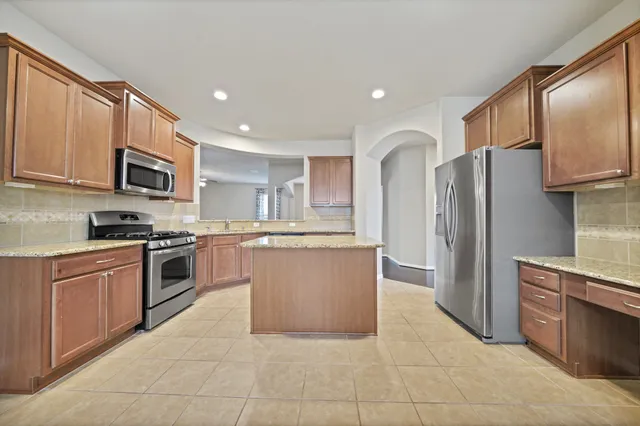 a large kitchen with cabinets stainless steel appliances and a window