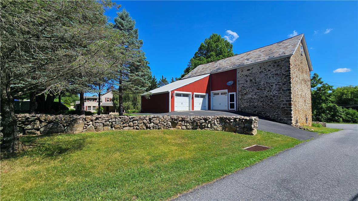 585 Buttermilk Road Hellertown, PA 18055 - Photo 64 of 82 Historic stone and wood barn with attached garages and paved driveway.