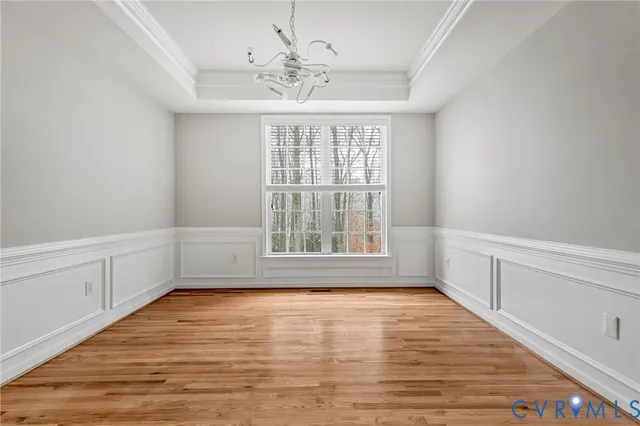 a view of an empty room with wooden floor fireplace and a window