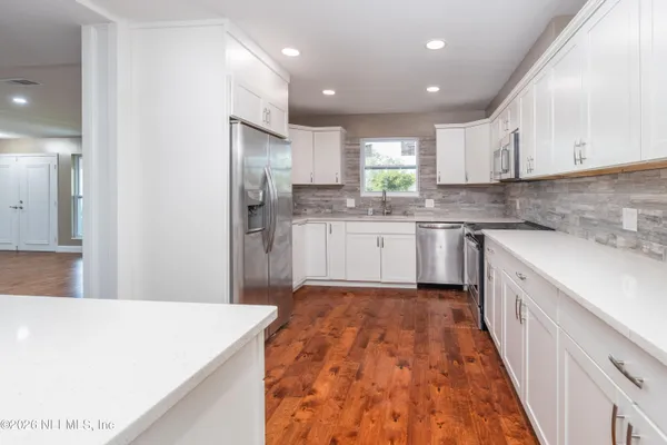 a kitchen with a sink a refrigerator and cabinets