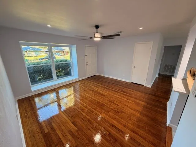 wooden floor in an empty room with a window