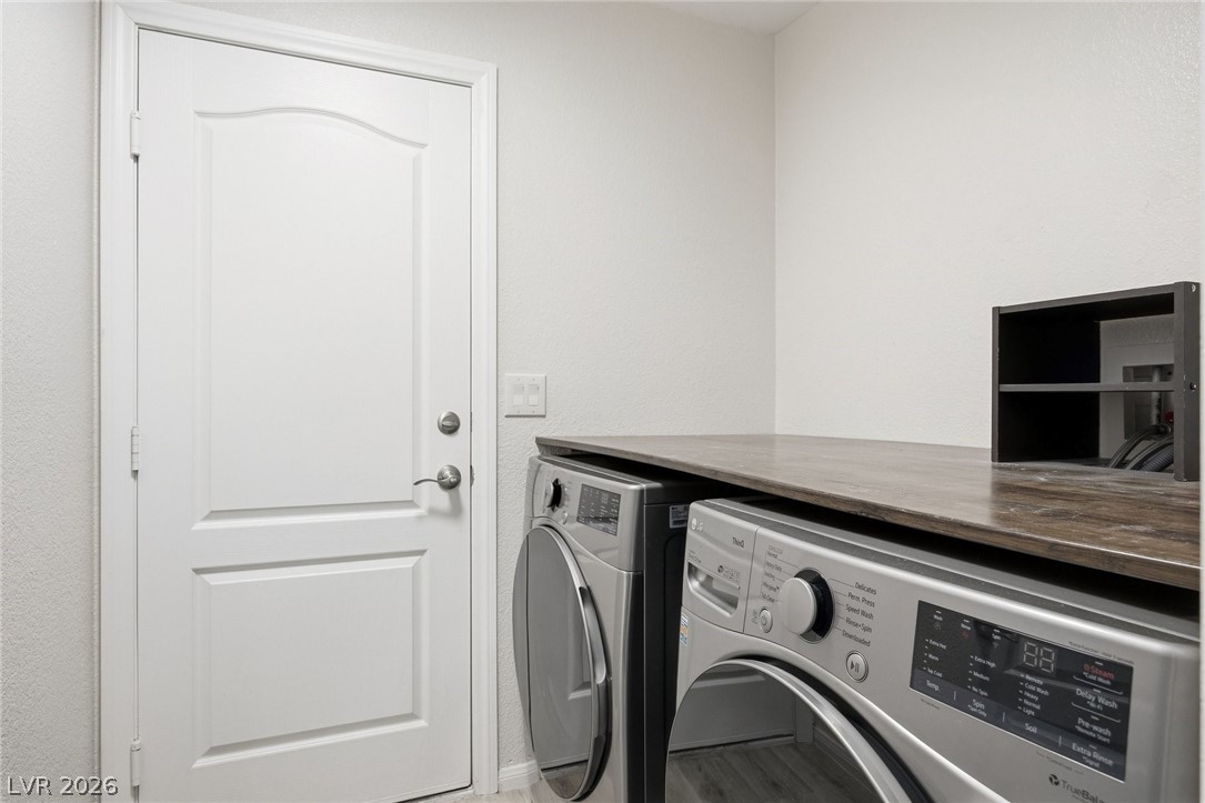 193 Oella Ridge Court Henderson, NV 89012 - Photo 25 of 32 Functional laundry room offers a washer and dryer beneath a spacious countertop, ready for household chores.