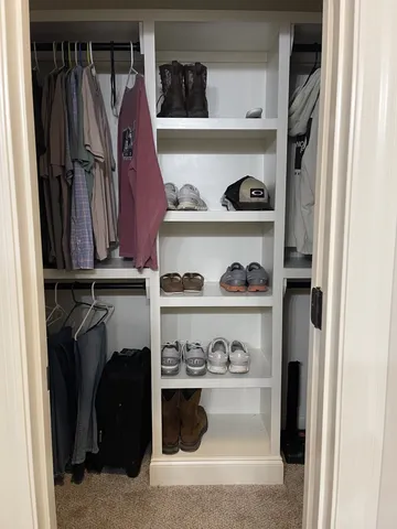 a view of walk in closet with clothes and shoes