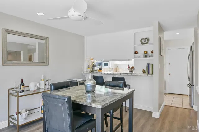 a kitchen with granite countertop a table chairs and wooden floor