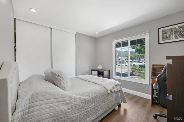 a bedroom with a bed and a flat tv screen on the dresser