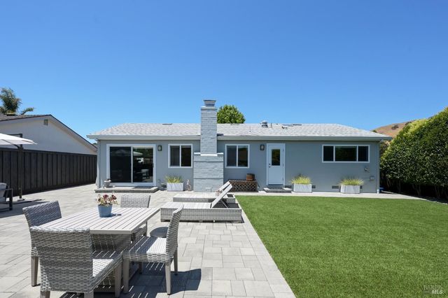 a view of a house with backyard sitting area and furniture