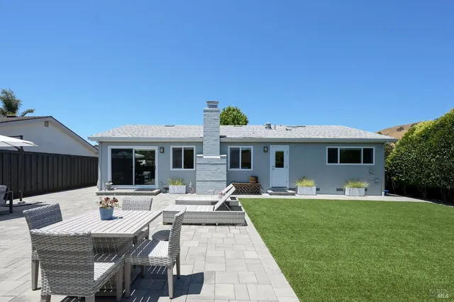 a view of a house with backyard sitting area and furniture